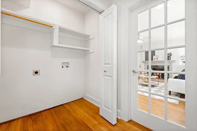 a view of a hallway with white walls and wooden floor