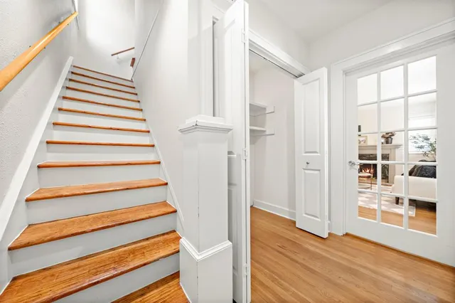 a view of a hallway with wooden floor and closet area
