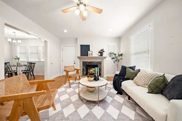 a living room with furniture a fireplace and a chandelier
