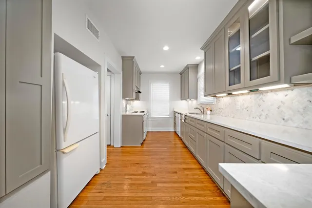 a large white kitchen with stainless steel appliances