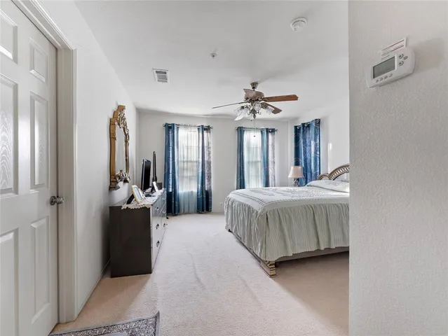 a spacious bedroom with a bed and a flat screen tv