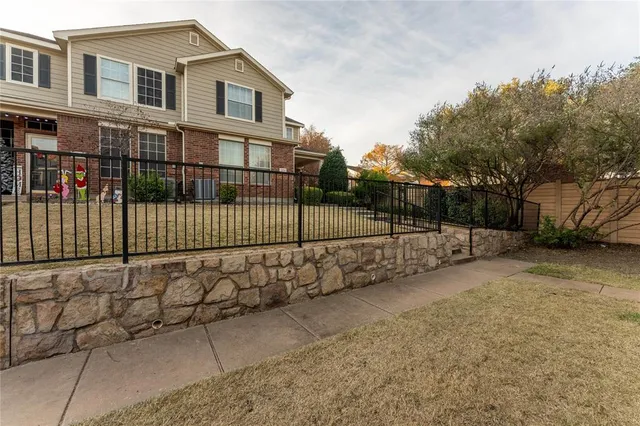 a view of a house with a wooden fence