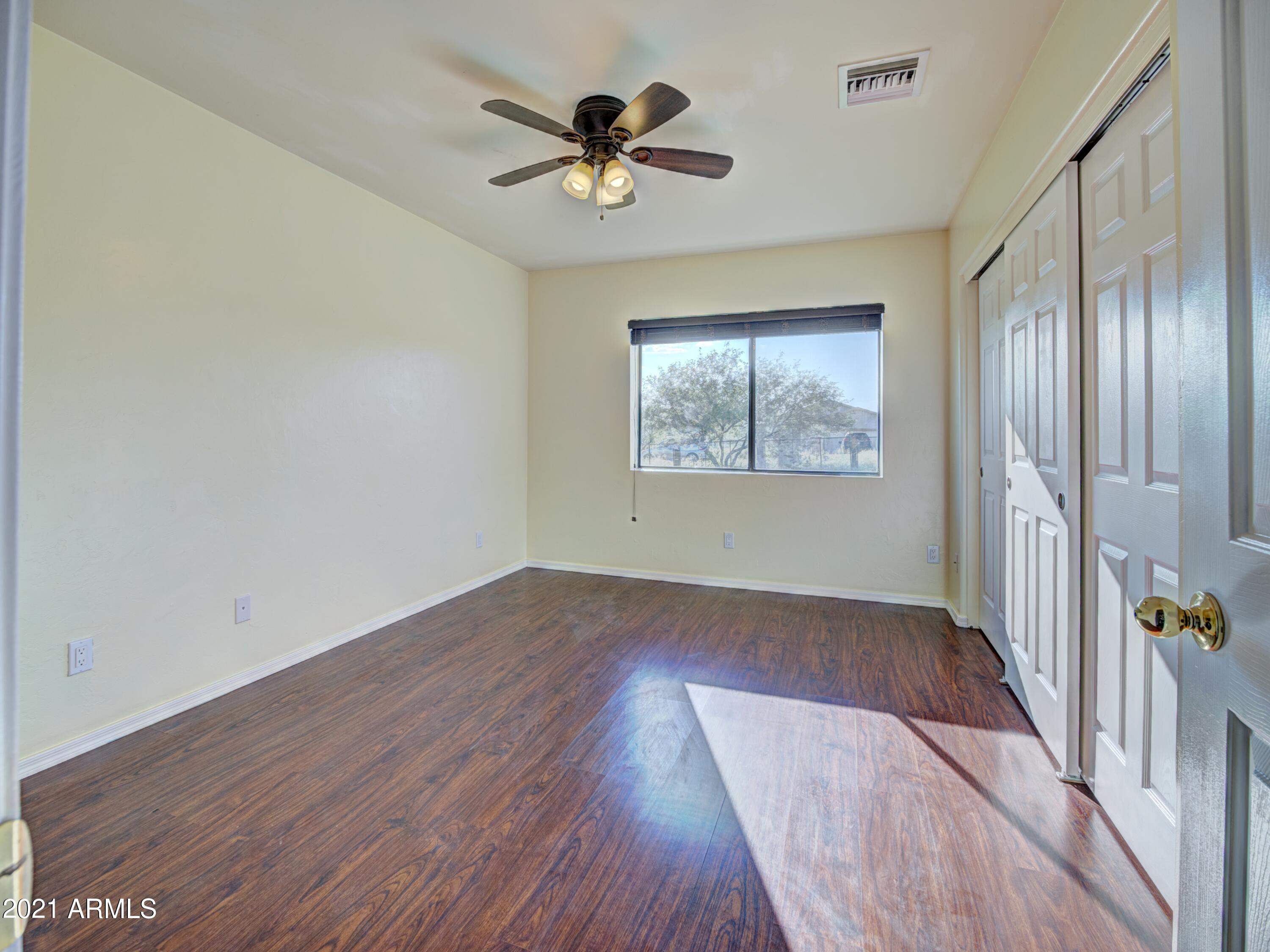 982 Circulo Tumbleweed Rio Rico, AZ 85648 - Photo 13 of 28 wooden floor in an empty room with a window