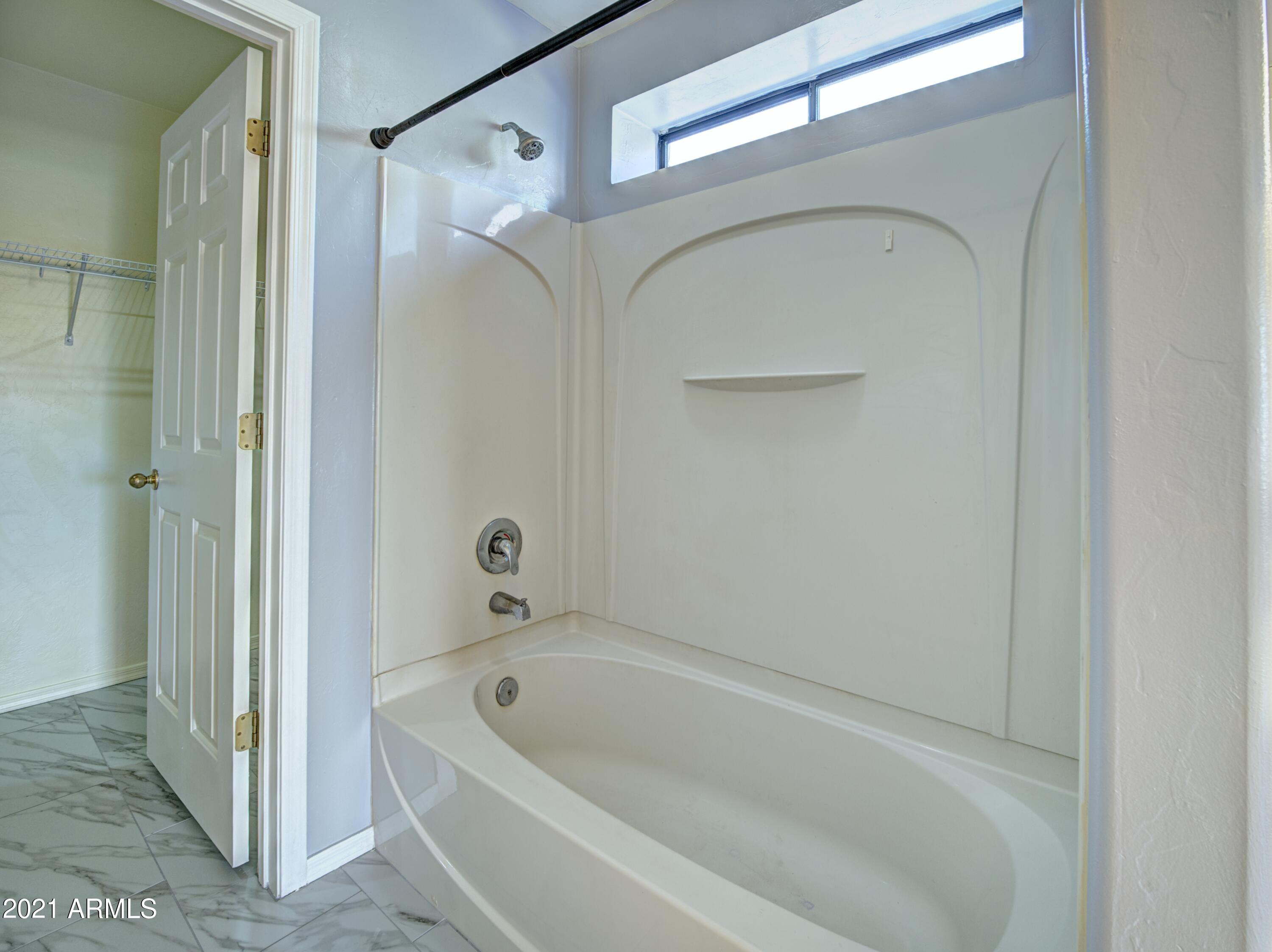 982 Circulo Tumbleweed Rio Rico, AZ 85648 - Photo 20 of 28 a bathroom with a tub and a shower