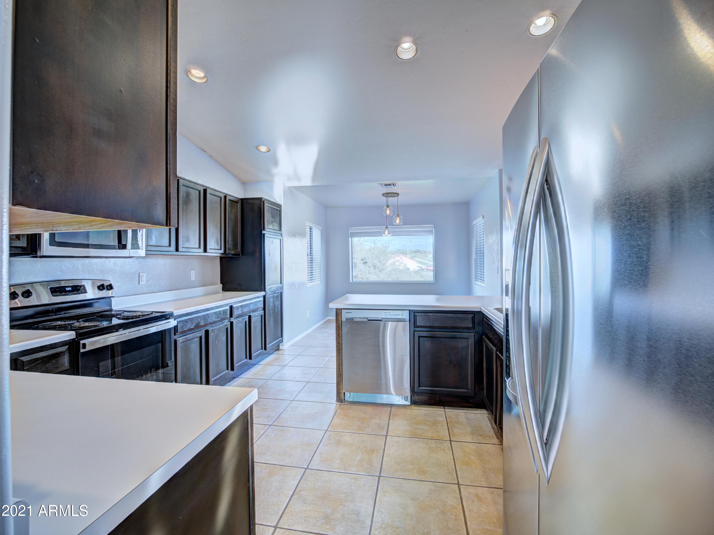 982 Circulo Tumbleweed Rio Rico, AZ 85648 - Photo 23 of 28 a kitchen with stainless steel appliances granite countertop a refrigerator and a stove top oven