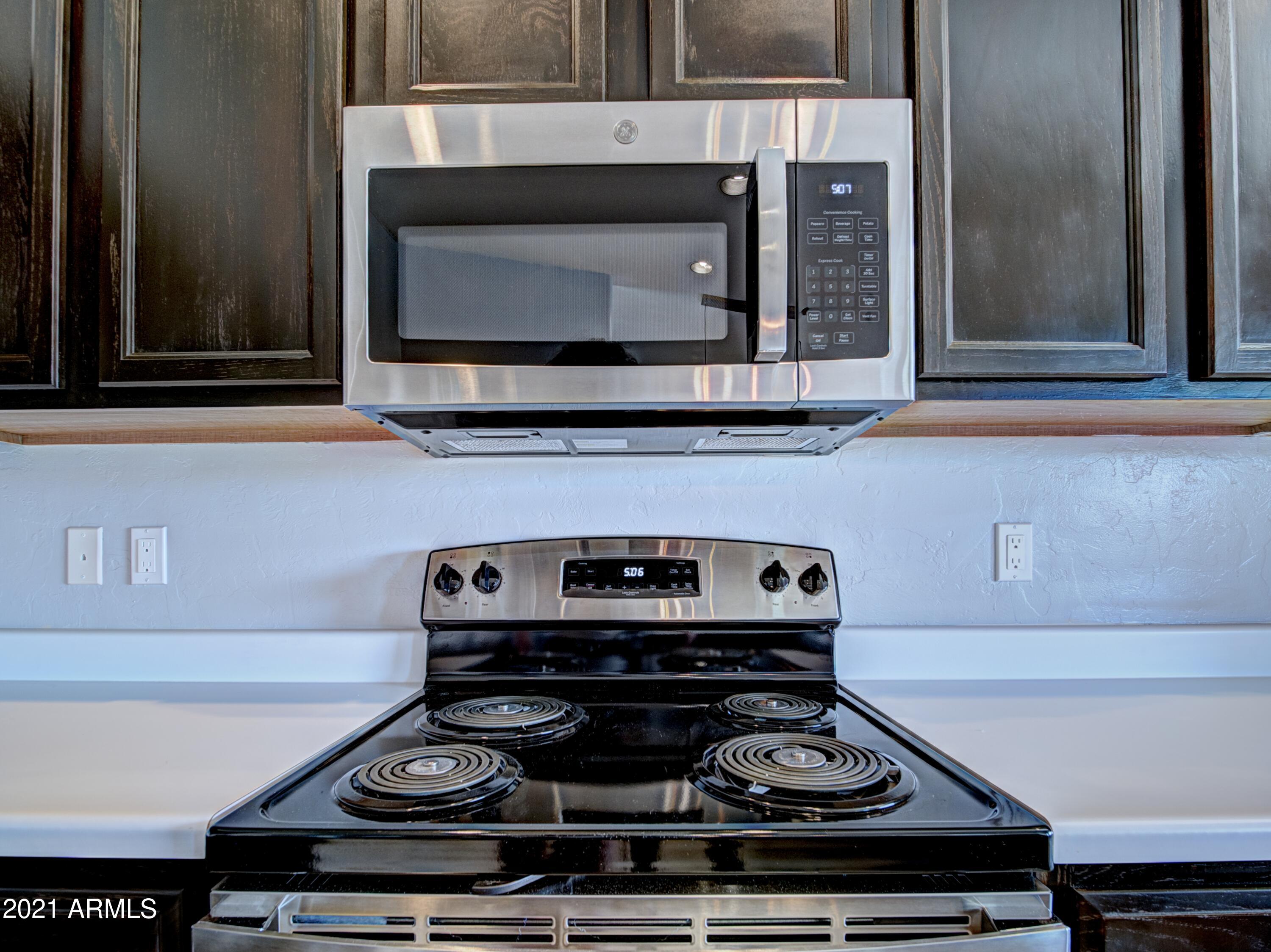 982 Circulo Tumbleweed Rio Rico, AZ 85648 - Photo 26 of 28 a stove top oven sitting inside of a kitchen