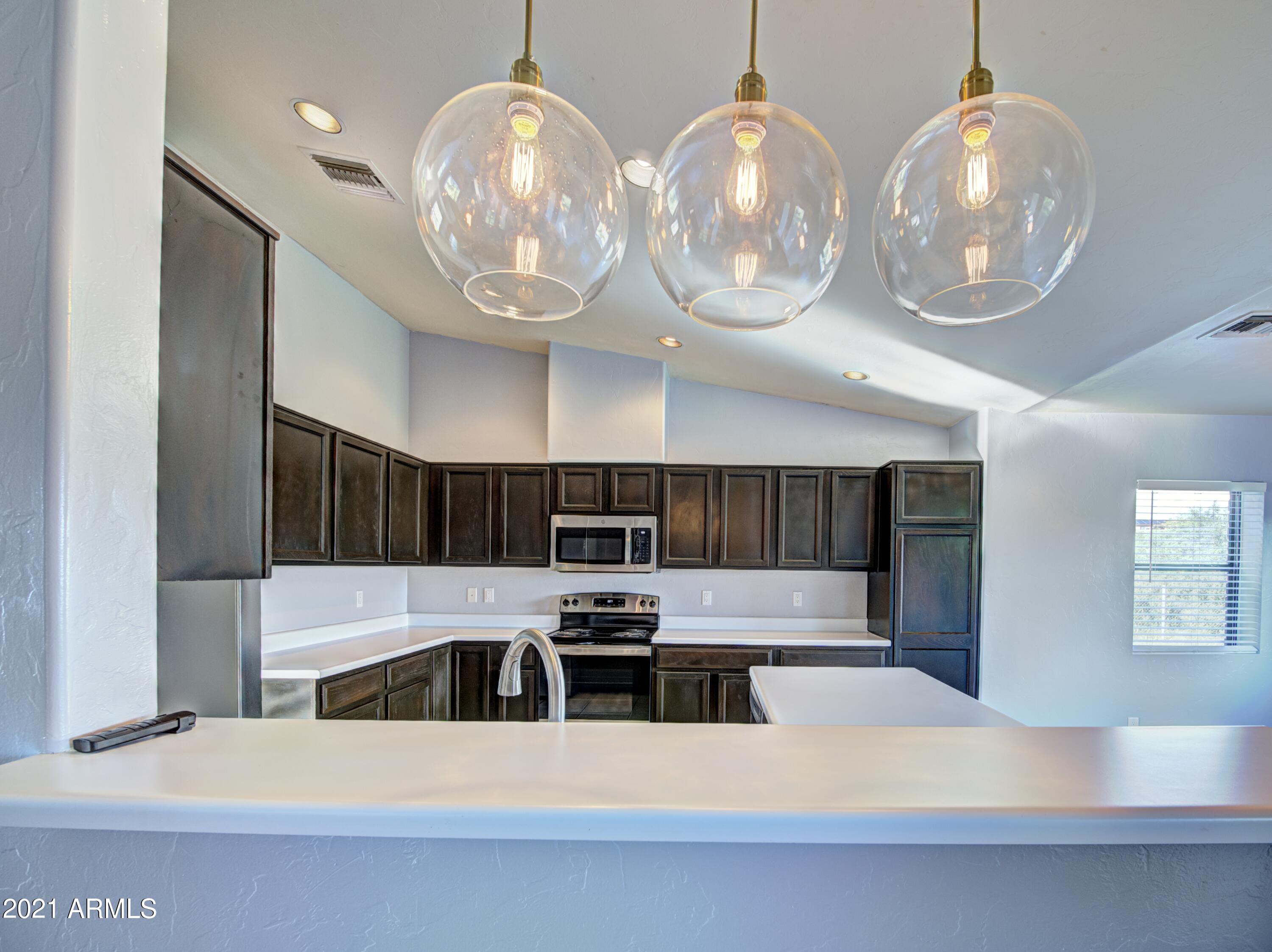 982 Circulo Tumbleweed Rio Rico, AZ 85648 - Photo 28 of 28 a kitchen with cabinets a sink and appliances