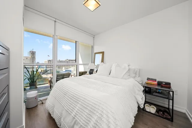 a bedroom with a bed table and a large window