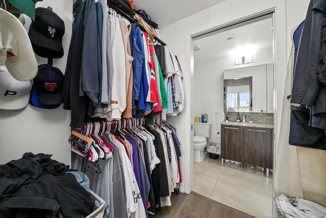 a view of walk in closet with clothes and shoes