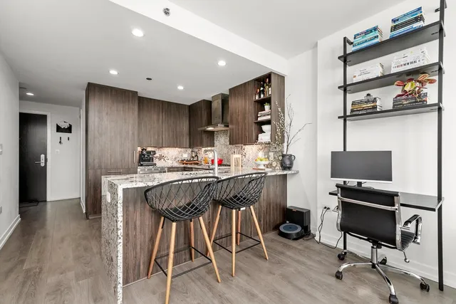 a kitchen with kitchen island granite countertop wooden floors and chairs