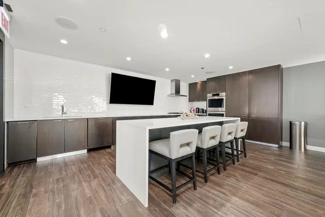a kitchen with a table chairs refrigerator and a sink