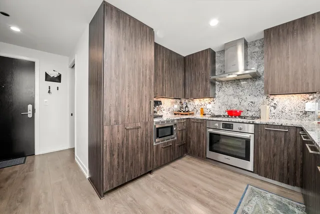 a kitchen with stainless steel appliances granite countertop a stove sink and cabinets