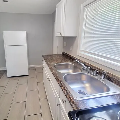 a kitchen with a sink a refrigerator and cabinets