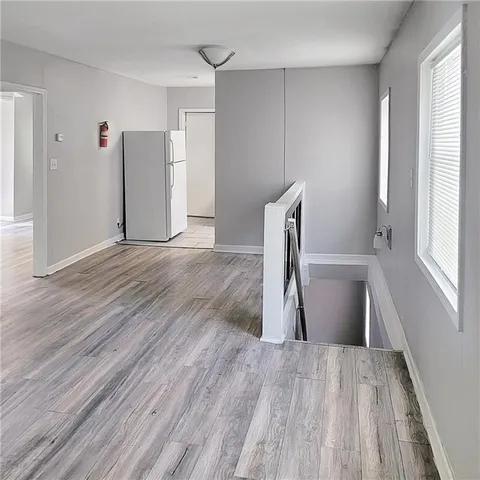 a view of empty room with wooden floor and window