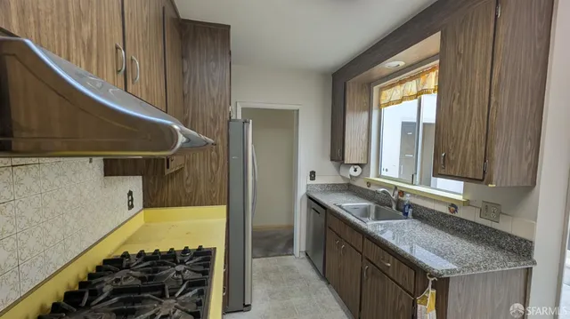 a bathroom with a granite countertop sink and a bathtub