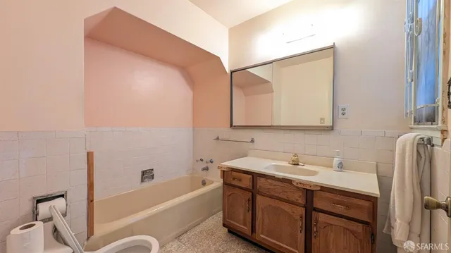a bathroom with a tub sink and mirror