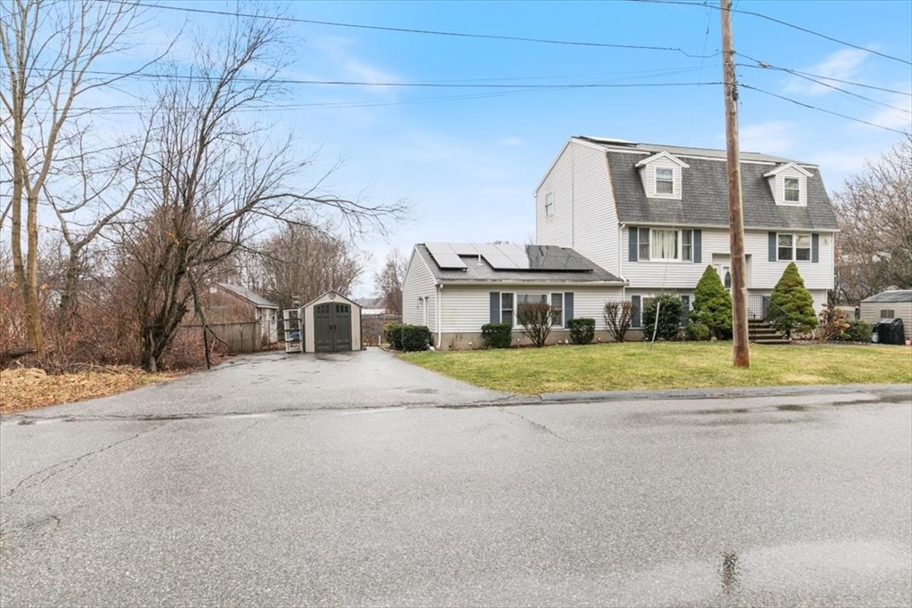 a view of a big house with a big yard and large trees