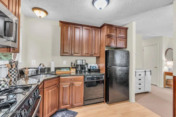 a kitchen with stainless steel appliances granite countertop a refrigerator stove and sink