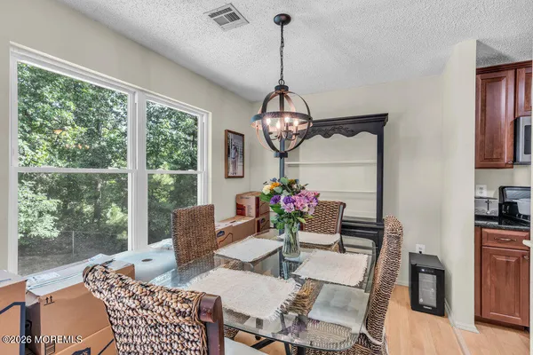 a dining room with furniture a chandelier and wooden floor