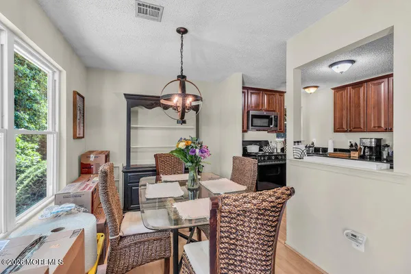 a kitchen with stainless steel appliances granite countertop a refrigerator a sink dishwasher a stove and a dining table with garden view