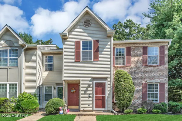 a front view of a house with a yard and trees