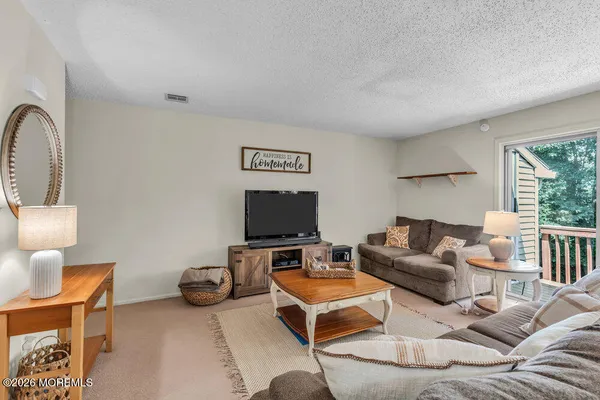 a living room with furniture a flat screen tv and a large window