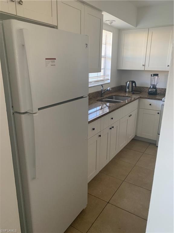 3325 Airport-Pulling Road North, Unit L1 Naples, FL 34105 - Photo 9 of 10 a white refrigerator freezer sitting inside of a kitchen