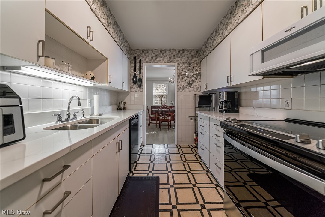 13800 Fairhill Road, Unit 306 Cleveland, OH 44120 - Photo 24 of 48 Kitchen featuring stainless steel appliances, white cabinetry, light stone counters, open shelves, and tasteful backsplash