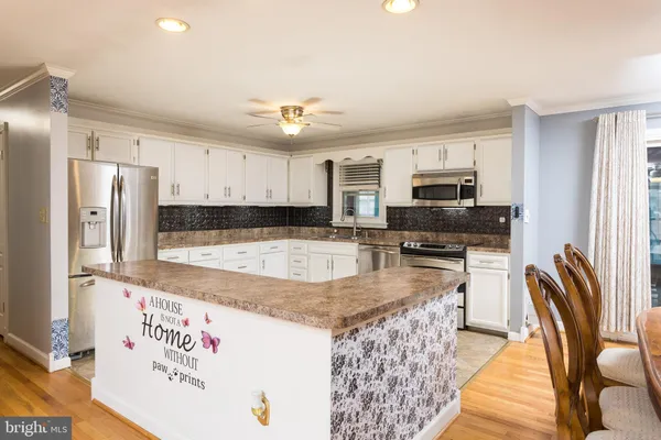 a kitchen with stainless steel appliances granite countertop a sink refrigerator and microwave