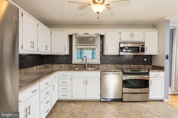 a kitchen with stainless steel appliances granite countertop a stove and a sink