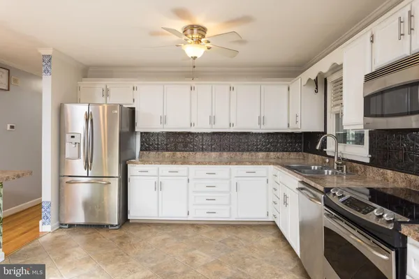 a kitchen with stainless steel appliances granite countertop a refrigerator a stove a sink and dishwasher