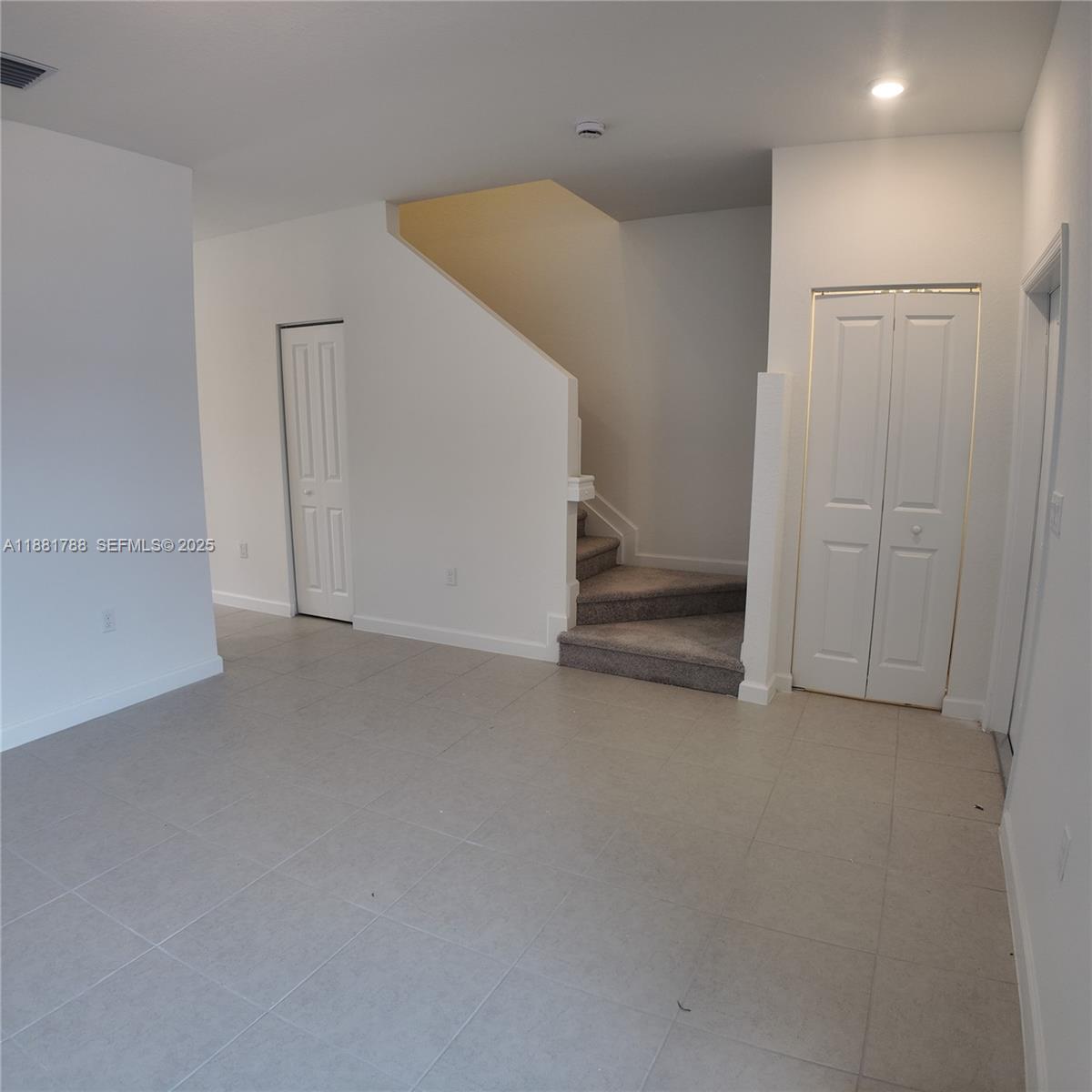 35761 Southwest 178th Court, Unit 35761 Homestead, FL 33034 - Photo 13 of 80 a view of an empty room with stairs and a hallway