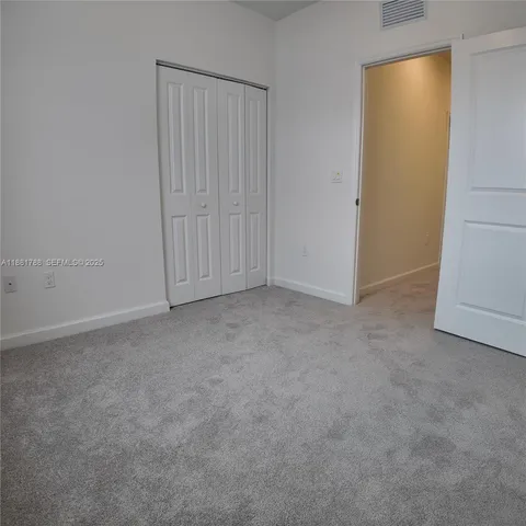 a view of an empty room with floor to ceiling windows