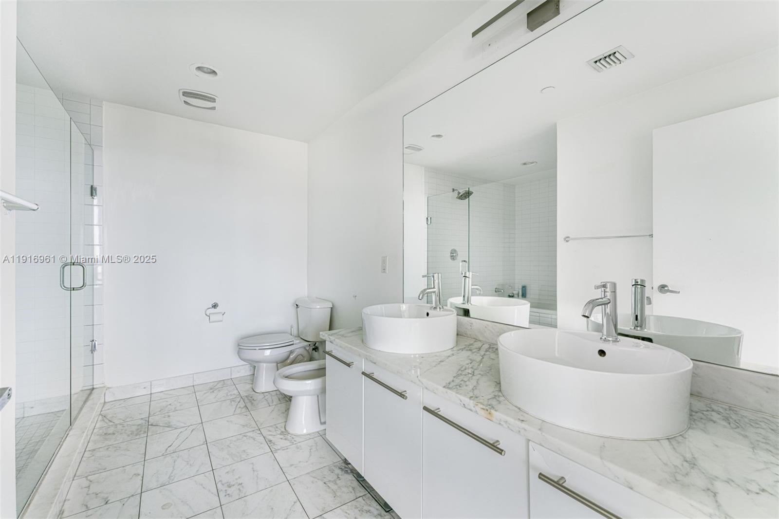 888 Biscayne Boulevard, Unit 1704 Miami, FL 33132 - Photo 12 of 20 a bathroom with a double vanity sink toilet and a mirror