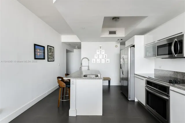 a kitchen with a sink a microwave a stove and refrigerator