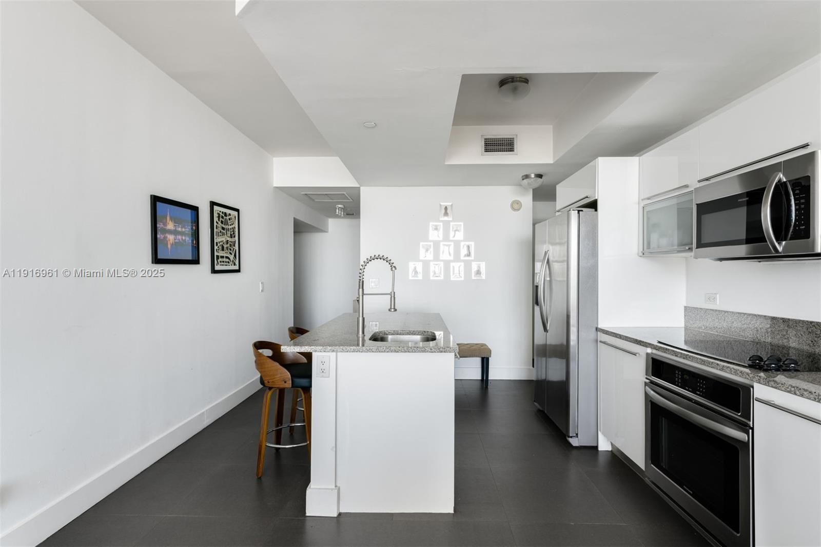888 Biscayne Boulevard, Unit 1704 Miami, FL 33132 - Photo 3 of 20 a kitchen with a sink a microwave a stove and refrigerator