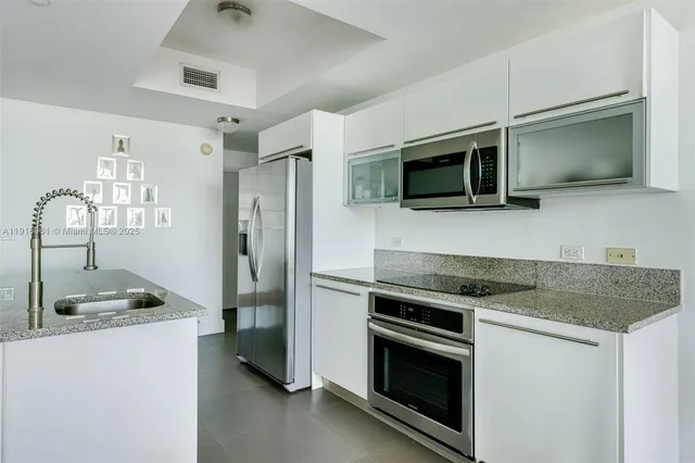 a kitchen with granite countertop a sink and stainless steel appliances