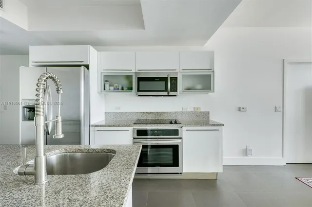 a kitchen with granite countertop a stove and a microwave