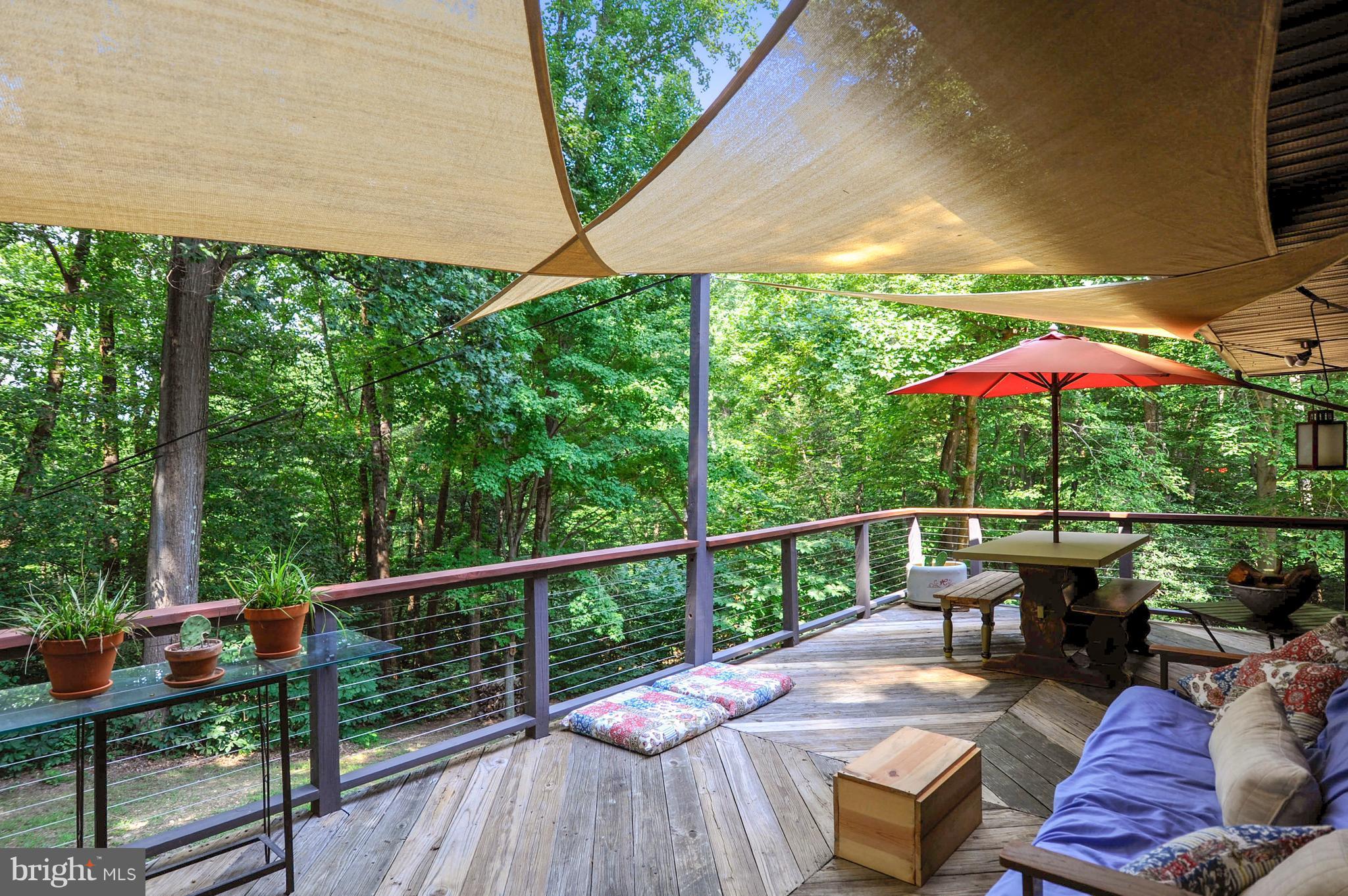401 Farmington Road West Accokeek, MD 20607 - Photo 21 of 30 a view of a patio with couches table and chairs under an umbrella with a small yard