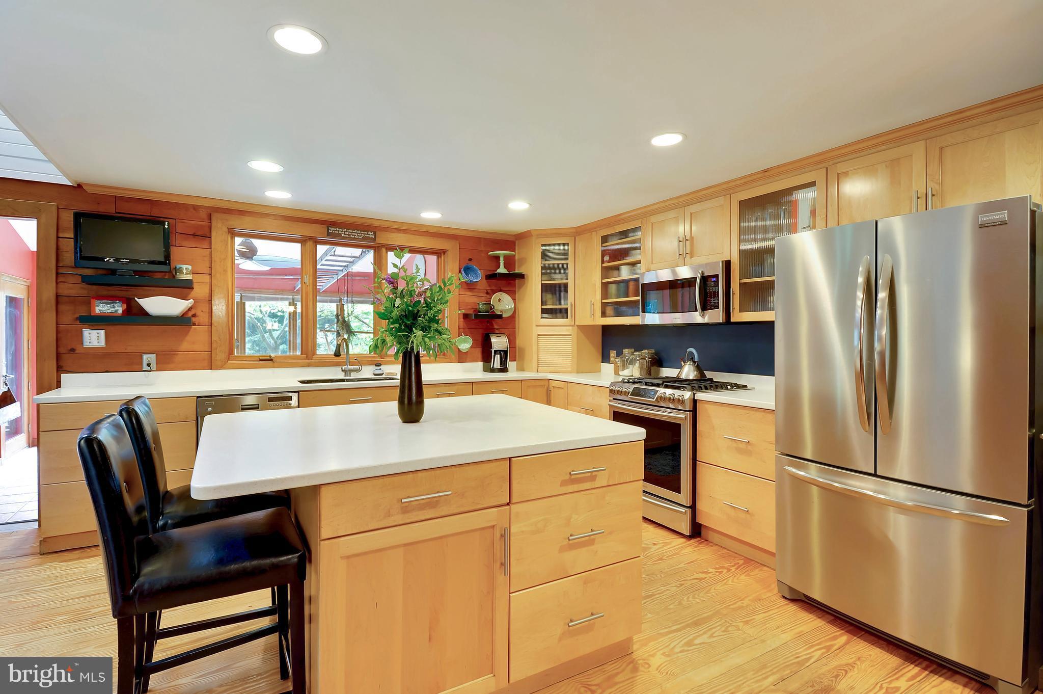 401 Farmington Road West Accokeek, MD 20607 - Photo 6 of 30 a kitchen with stainless steel appliances granite countertop a refrigerator a stove a sink a dining table and chairs with wooden floor