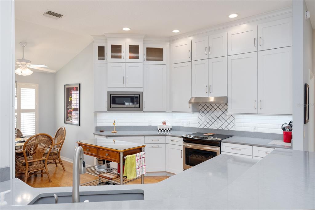 1348 Honea Path The Villages, FL 32162 - Photo 13 of 82 a kitchen with stainless steel appliances granite countertop a stove and white cabinets