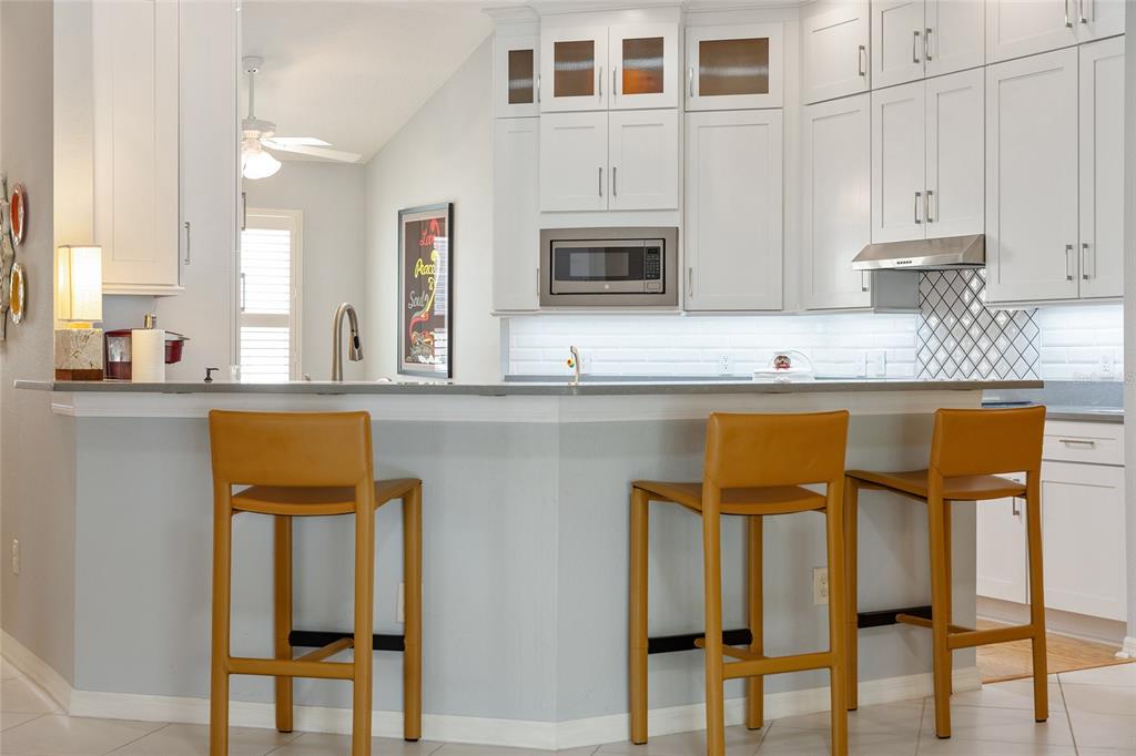 1348 Honea Path The Villages, FL 32162 - Photo 19 of 82 a kitchen with stainless steel appliances granite countertop a stove top oven a sink and white cabinets with wooden floor