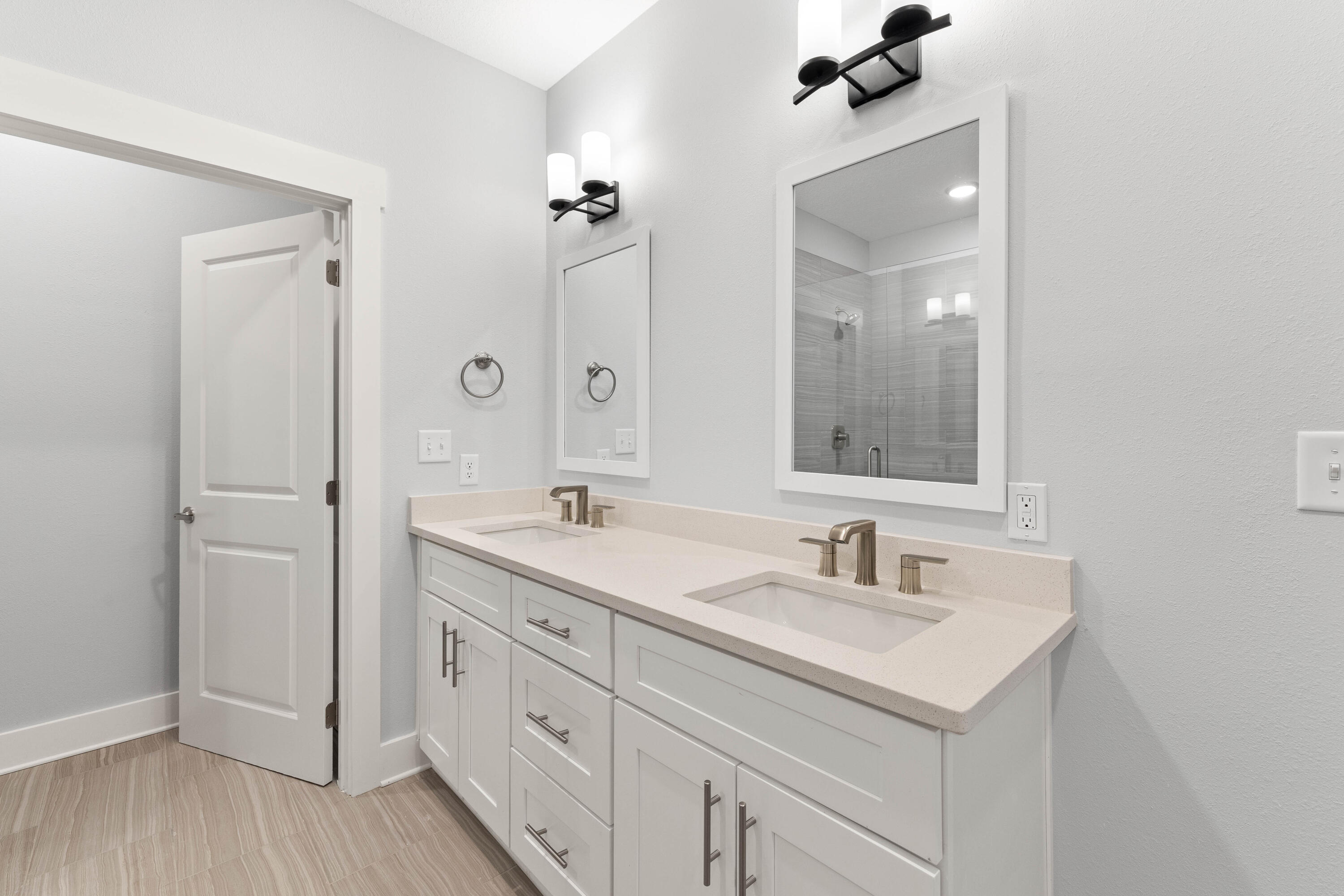 100 Beach Drive, Unit 7 Destin, FL 32541 - Photo 19 of 33 a bathroom with double sink a mirror and a wooden cabinets