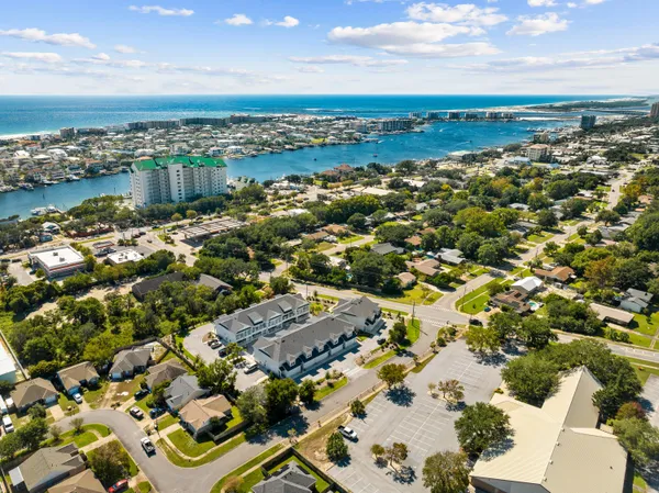 an aerial view of a residential houses with outdoor space and ocean view