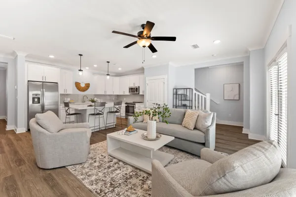 a living room with furniture kitchen view and a window