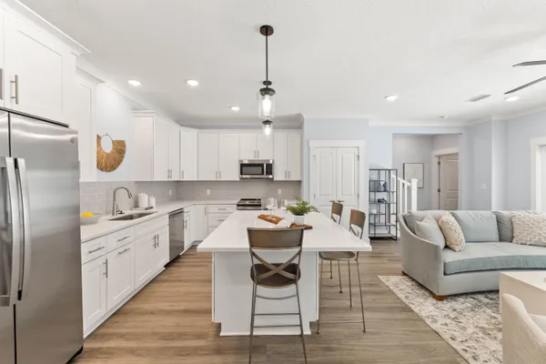 a kitchen with a refrigerator and white cabinets