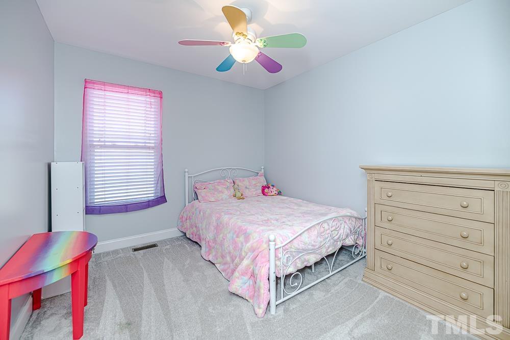 1652 Tingen Road Lillington, NC 27546 - Photo 16 of 30 a bedroom with a bed and a chandelier