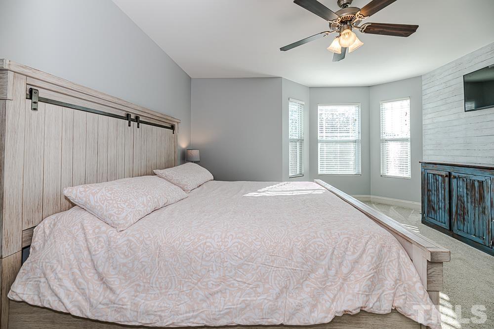 1652 Tingen Road Lillington, NC 27546 - Photo 18 of 30 a spacious bedroom with a bed and a chandelier