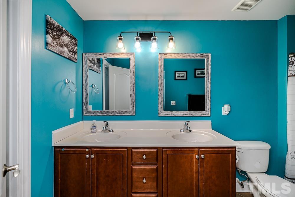 1652 Tingen Road Lillington, NC 27546 - Photo 21 of 30 a bathroom with a sink and mirror