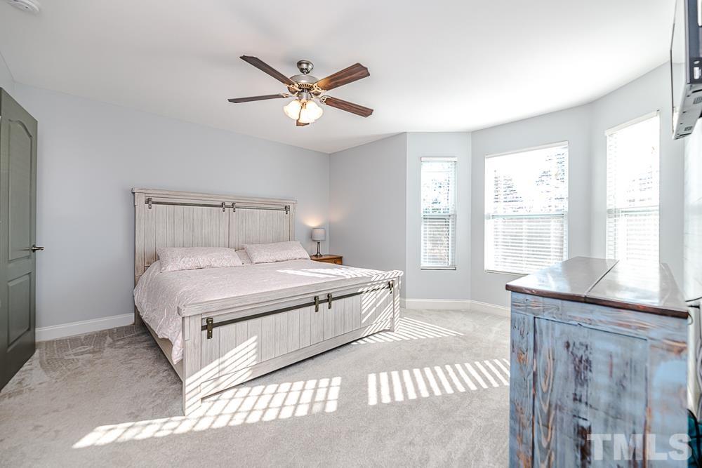 1652 Tingen Road Lillington, NC 27546 - Photo 23 of 30 a spacious bedroom with a large bed and a chandelier